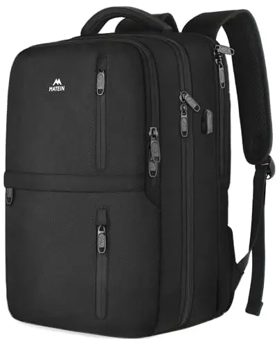 MATEIN black travel backpack with USB port open on a luggage trolley