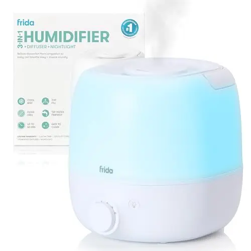 Frida Baby white compact humidifier with a top carry handle in a nursery setting.